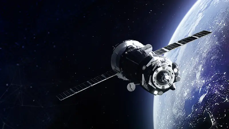 Ein Satellit kreist um die Erde. Bild führt weiter zur Branche "Luft- und Raumfahrt".