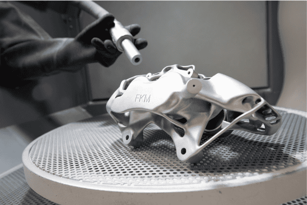 3D-gedrucktes Metallbauteil auf Drehteller während der Oberflächenbearbeitung bei FKM